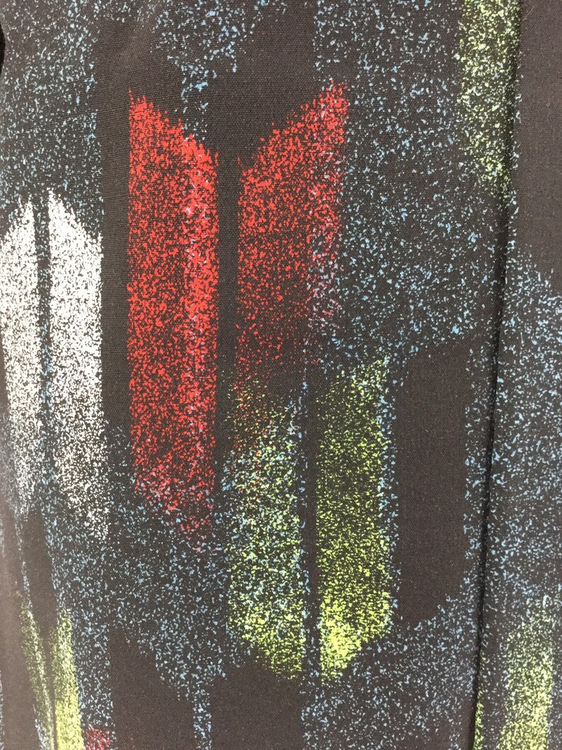 May include: Abstract fabric with a black background and colorful vertical stripes. The stripes are red, white, green, and blue. The fabric has a speckled texture.
