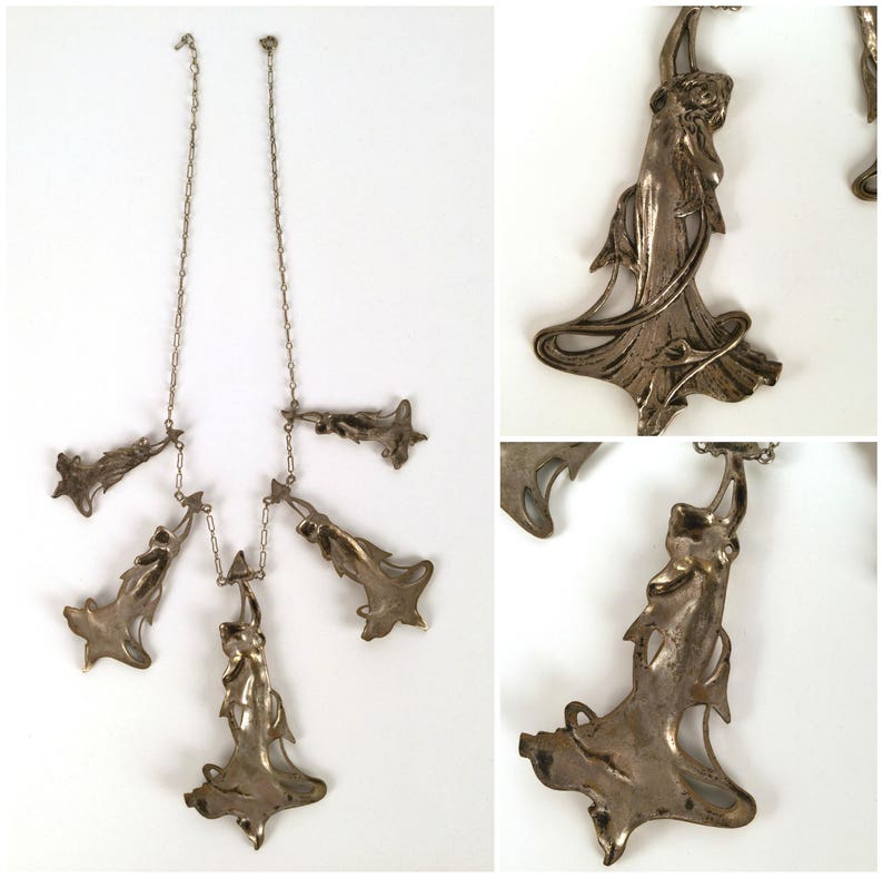 May include: A silver necklace with five pendant charms, each featuring a stylised female figure in a flowing gown. The charms are connected to a delicate silver chain.