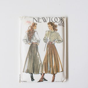 Peut inclure: Patron de couture New Look 6012 vintage. Le patron présente des illustrations de deux femmes portant des jupes longues et des chemisiers. L'enveloppe du patron est blanche avec le nom de la marque et le numéro de style imprimés en noir.