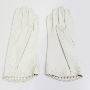 May include: A pair of white leather gloves with a ribbed cuff.