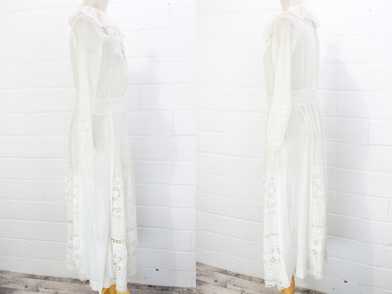 May include: A white maxi dress with long sleeves and a lace trim. The dress has a ruffled collar and a fitted bodice.
