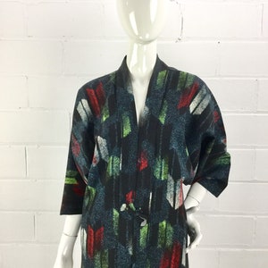 May include: A black, green, red, and white patterned kimono with a long sleeve. The kimono has a traditional Japanese design and is made of a soft, lightweight fabric.