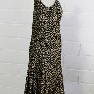 May include: A black and gold sleeveless dress with a zebra print pattern. The dress has a fitted bodice and a flared skirt.