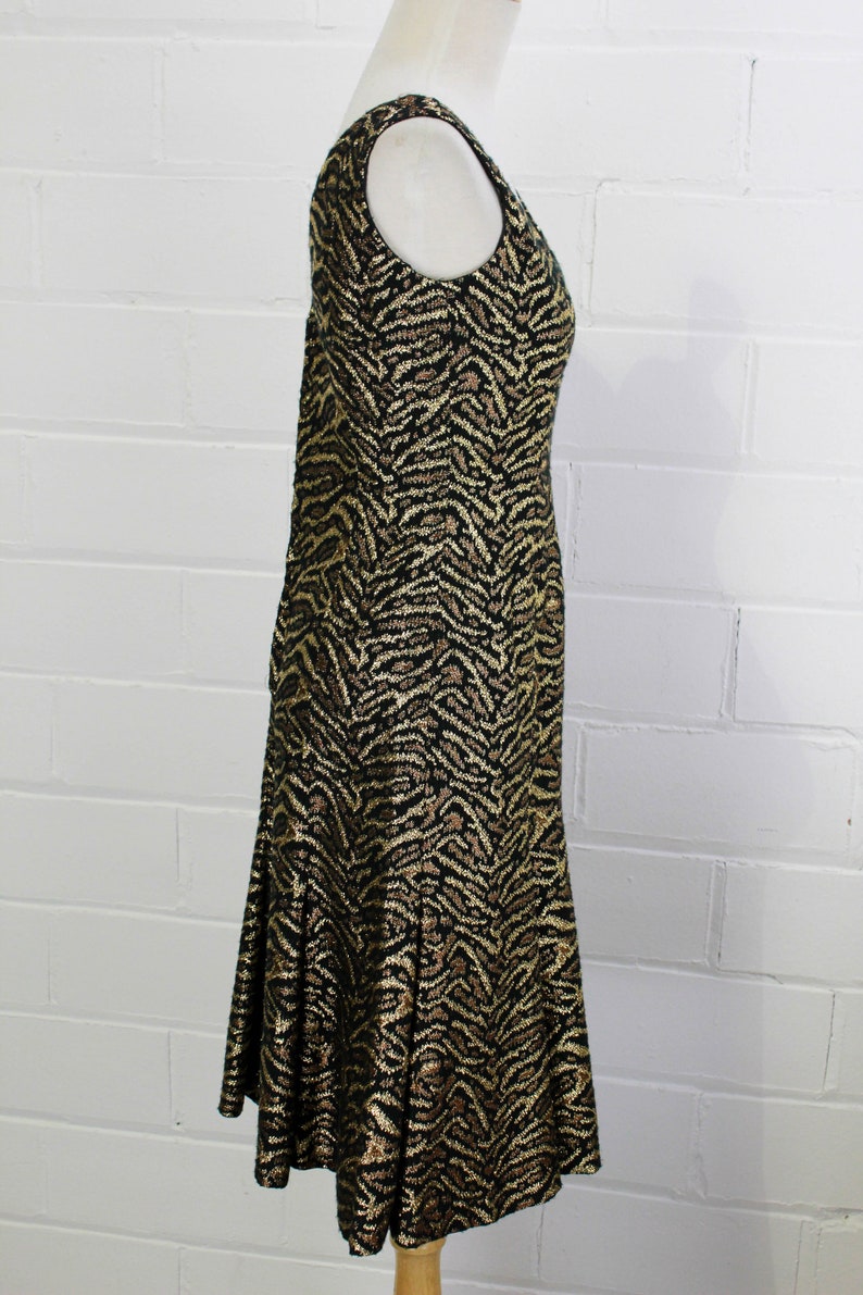 May include: A black and gold sleeveless dress with a zebra print pattern. The dress has a fitted bodice and a flared skirt.