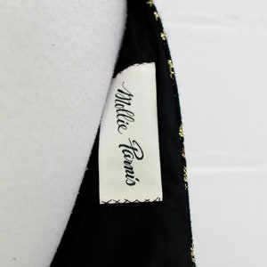 May include: A black and gold dress with a white tag that says "Millie Paris".