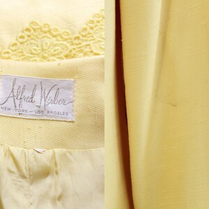 May include: A yellow blazer with a label that reads "Alfred Weber, New York - Los Angeles". The blazer has a lace trim at the top.