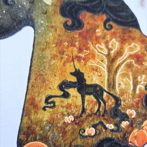 May include: Wooden art piece featuring a black unicorn silhouette in a forest scene with pumpkins. The artwork has a warm color palette of orange, yellow, and brown, with a full moon and dark hair details.