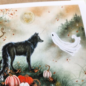 May include: A black wolf with a white horn stands in a misty forest with a white ghost. The forest floor is covered in fallen leaves and there are pumpkins in the foreground.