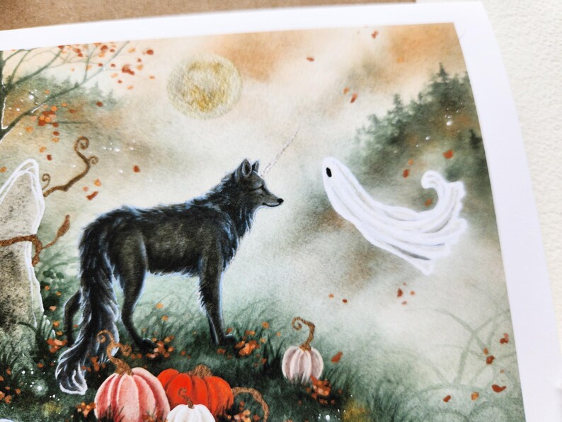 May include: A black wolf with a white horn stands in a misty forest with a white ghost. The forest floor is covered in fallen leaves and there are pumpkins in the foreground.