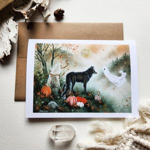 May include: A black wolf stands in a forest setting with a white ghost beside it. The scene is painted in watercolor with fall foliage and pumpkins.
