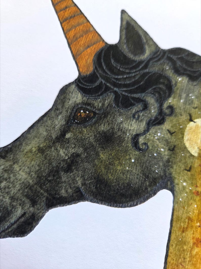 May include: A detailed illustration of a unicorn's head. The unicorn has a dark gray coat, a brown and orange horn, and black curly hair. The background features a moon, stars, and flying birds.