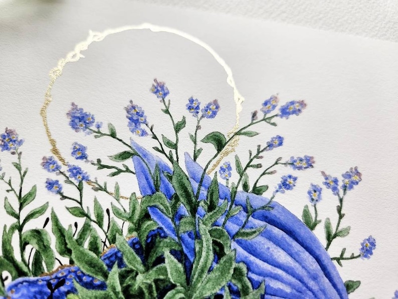 K&ouml;nnte beinhalten: Aquarellmalerei von blauen Vergissmeinnicht-Blumen mit gr&uuml;nen Bl&auml;ttern und einem goldenen Kreis darum.