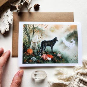 May include: A watercolor illustration of a black wolf standing in a forest with a white ghost and pumpkins. The scene is set in a foggy forest with fall leaves and a full moon in the background.