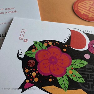 K&ouml;nnte beinhalten: Eine schwarze und rote Illustration eines Schweins mit einer rosa Blume und gr&uuml;nen Bl&auml;ttern. Das Schwein ist von orangefarbenen und gelben Punkten umgeben. Das chinesische Schriftzeichen f&uuml;r "Schwein" ist in Rot &uuml;ber dem Schwein geschrieben. Der Text "PIG" ist in Rot &uuml;ber dem Schriftzeichen geschrieben. Der Text "2018 DSwansonKleinke. Images may not be reproduced without the artist's written permission." ist in Schwarz am unteren Rand des Bildes geschrieben.