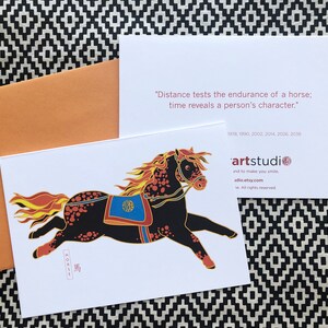 May include: A black and orange horse with a yellow mane and tail, running to the right. The horse is wearing a blue and gold saddle. The image is on a white background with the text "HORSE" and a Chinese character for "horse" in red ink. The text "Distance tests the endurance of a horse; time reveals a person's character." is on the back of the card. The text "artstudio" and "adio.etsy.com" are also on the back of the card.