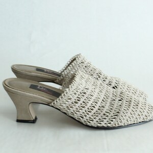 Könnte beinhalten: Beigefarbene gewebte Sandalen mit Absatz, geschlossenem Zeh und einem dicken Absatz.