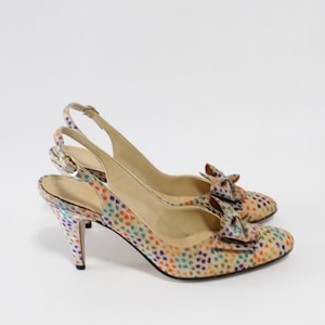 Könnte beinhalten: Ein Paar beigefarbene Slingback-Heels mit einem bunten Tupfenmuster und einer Schleife an der Spitze.