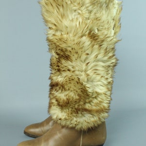 May include: Brown leather boots with a faux fur cuff. The fur is a light brown color with darker brown streaks.