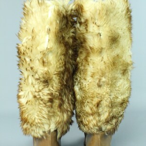May include: A pair of brown leather boots with faux fur trim. The boots have a high heel and a pointed toe.