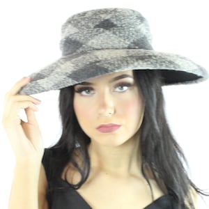 May include: A woman wearing a wide-brimmed gray and white patterned hat. The hat has a soft, fuzzy texture.