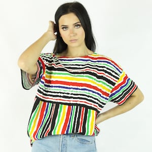 May include: A colorful striped shirt with short sleeves. The shirt has a black background with horizontal stripes of red, yellow, green, blue, and white.