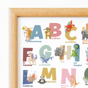 May include: A framed alphabet print with colorful letters and animal illustrations. Each letter is paired with a positive affirmation, such as "be Brave" and "be Adventurous." The artwork features a light wood frame.