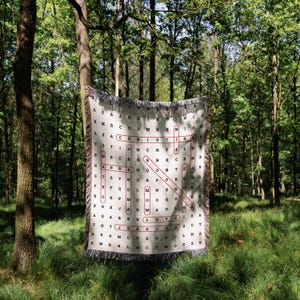 May include: A white woven blanket with a red and black word search pattern. The pattern includes the words "LOVE", "MOM", "JESSICA", and "CHRISTMAS".