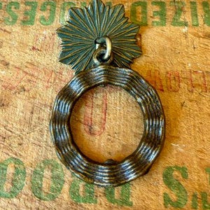 Piccola maniglia per cassetto in ottone anticato, accessorio decorativo.