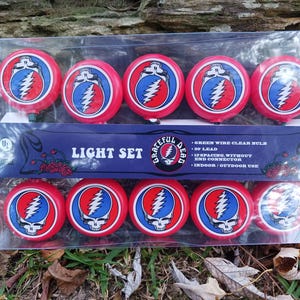 May include: A set of 10 red and blue Grateful Dead logo string lights with a clear bulb. The lights are packaged in a clear plastic bag with a blue and white cardboard backing that says "Grateful Dead Light Set".