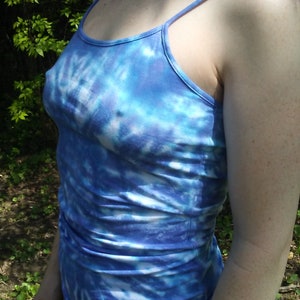 May include: A blue and white tie-dye tank top with thin straps. The tank top is made of a soft, stretchy fabric.