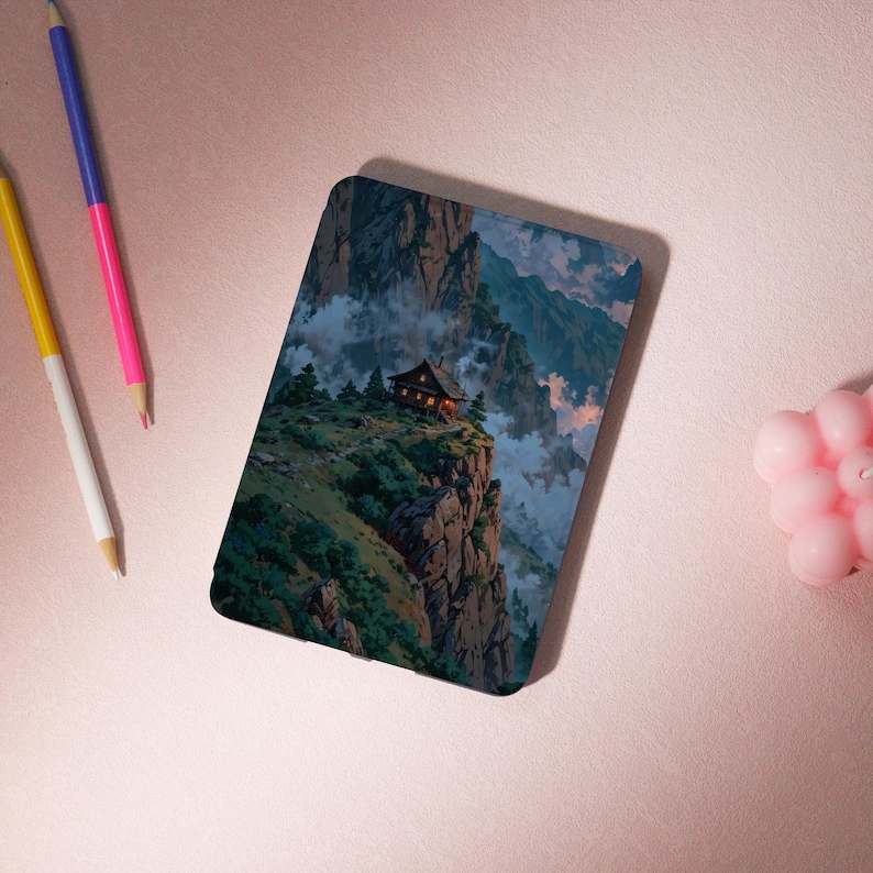 May include: A rectangular phone case featuring a scenic landscape of a mountain range with a small cabin on a cliff. The artwork depicts a cabin with lights on, surrounded by green trees, clouds, and mountains. The case has a glossy finish.