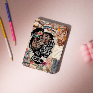 May include: A digital illustration of a woman with a floral crown standing in front of a bookshelf filled with books. The text reads "& into the library she goes to lose her MIND and find her SOUL".