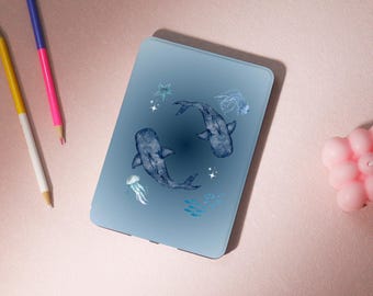 May include: A blue e-reader case with a watercolor design of two fish swimming in a circle. The design also includes stars, jellyfish, and small fish.