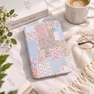 May include: A rectangular e-reader case featuring a patchwork design of various floral, gingham, and striped patterns in soft pastel shades of pink, blue, green, and white. The surface displays a collage of botanical prints and geometric motifs.