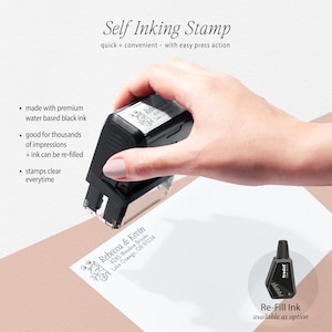 May include: A black self-inking stamp with a floral design and the text "Rebecca & Kevin 4285 Meadow Brooks Lake Oswego, OR 97034". The stamp is being held by a hand. A small bottle of black ink is shown in the bottom right corner with the text "Re-Fill Ink available as option".