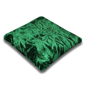 May include: A square, emerald green velvet cushion. The cushion has a soft, plush texture.
