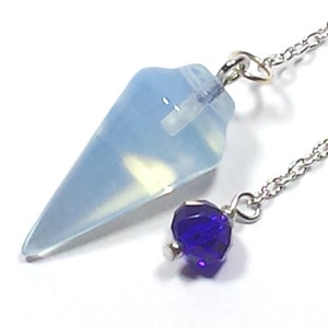 May include: A white opal pendulum with a silver chain and a dark purple crystal at the end.