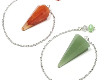 May include: Two crystal pendulums with silver chains. One pendulum is orange, the other is green. Each has a faceted, cone-shaped crystal attached to a silver chain. The chains are connected to a cluster of colorful beads.