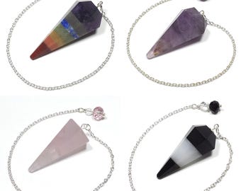 May include: Four crystal pendulums with silver chains and decorative beads. The pendulums are in various colors: a rainbow-colored one, a purple one, a pink one, and a black and white one. Each pendulum is a different type of crystal.