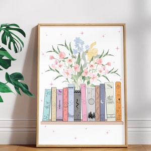 May include: A framed art print depicting a bookshelf with illustrated book spines. Above the books is a bouquet of pink, yellow, and blue flowers. The print is in a wooden frame and set against a white background. The print is on a wooden floor.