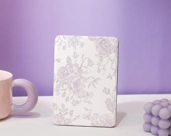 May include: A white book cover with a floral pattern in shades of gray. The flowers are a delicate design of roses and other blooms.