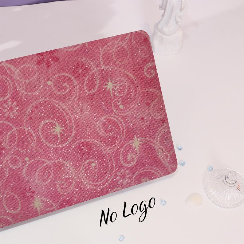 May include: A pink rectangular object with a swirling, floral pattern and the text "No Logo" in black script. The design includes white stars and dots. The object is on a white surface.