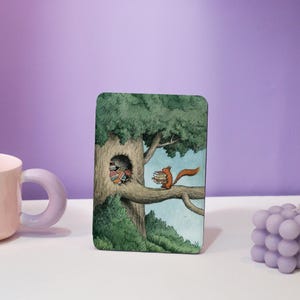 May include: A whimsical illustration of a squirrel carrying a stack of books on a branch of a tree. The squirrel is brown and has a bushy tail. The tree is green and has a hollow trunk filled with more books.
