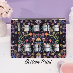 May include: Black laptop skin with a colorful floral and fruit design. The design features birds, flowers, and fruit in shades of red, yellow, green, and purple. The background is black with a white and black striped pattern. The text "Bottom Print" is printed below the image.