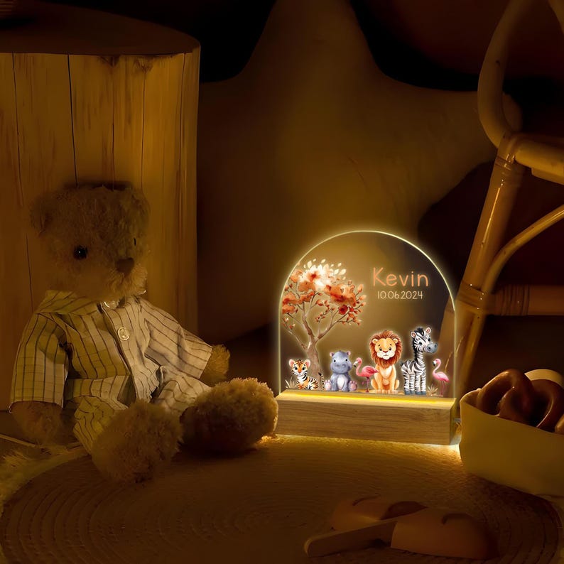 May include: A wooden night light with a clear acrylic insert featuring a jungle scene with animals, a tree, and the name "Kevin" and the date "10.06.2024".