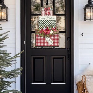 May include: A Christmas-themed door decoration featuring three stacked boxes. The top box has a red and white striped pattern with a bow. The middle box reads "Merry Christmas" on a green polka dot background. The bottom box has a red plaid pattern and floral accents.