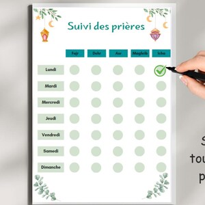 May include: A printable daily prayer tracker with a minimalist design. The tracker includes a checklist for each day of the week and five daily prayers: Fajr, Dhuhr, Asr, Maghrib, and Isha. The tracker is decorated with green leaves and a lantern.