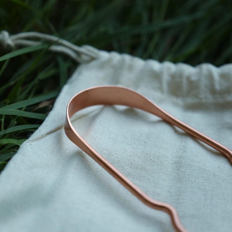 Eso World pure copper tongue scraper — traditional Ayurvedic oral care tool designed to remove buildup and support fresh breath naturally. Handcrafted from 100% pure copper for its antimicrobial and detoxifying properties. Durable, reusable, and fully recyclable alternative to plastic scrapers. Ideal for daily natural oral hygiene, zero-waste living, and holistic wellness routines. Part of Eso World’s premium eco-friendly essentials collection