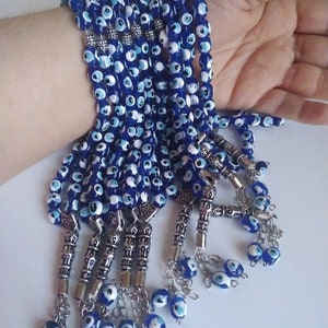 Peut inclure: Un ensemble de chapelets de pri&egrave;re en perles bleues et blanches avec des breloques argent&eacute;es. Les perles sont enfil&eacute;es sur une cha&icirc;ne argent&eacute;e et ont un pompon &agrave; l'extr&eacute;mit&eacute;.