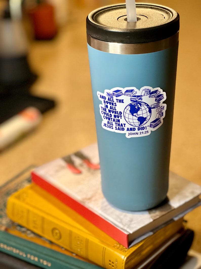 May include: A blue stainless steel travel mug with a sticker that says "And all the books in all the world could not contain all that Jesus said and did! John 21:25". The sticker features a globe surrounded by books.